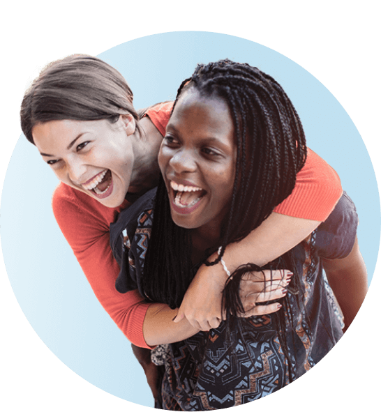 Young female friends hugging and smiling