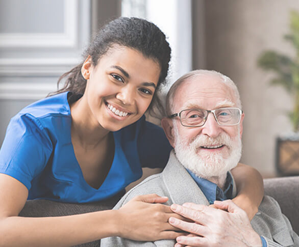 Caring nurse hugging older male patient