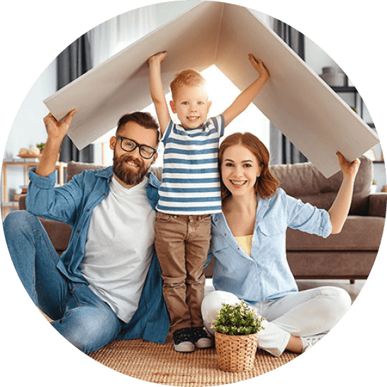 Parents with young boy holding up a pretend cardboard roof in living room