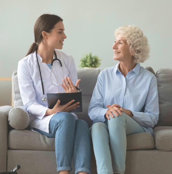 Respiratory therapist sitting on couch with older female patient talking through care plan