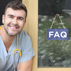 Nurse sitting next to door with FAQ sign