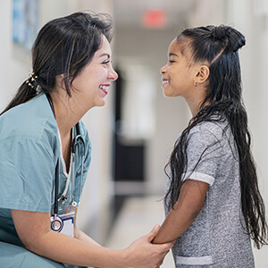 Nurse looking at pediatric patient smiling