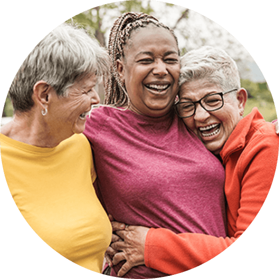 Smiling older woman being hugged by her two friends