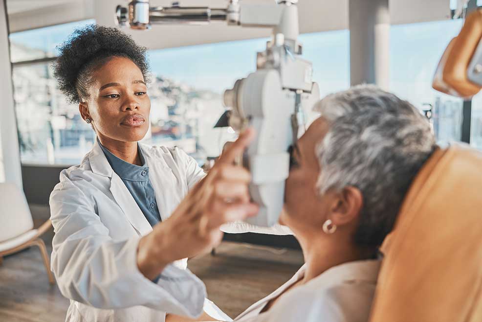 Eye doctor checking patient's eyes in office