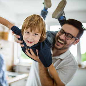 Happy boy having fun with his father in the kitchen