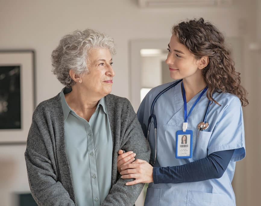 Nurse walking with older female patient at home